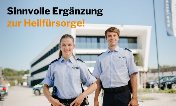Eine junge Polizistin steht neben einem jungen Polizisten. Beide lächeln und im Hintergrund ist die Polizeiwache zu sehen.