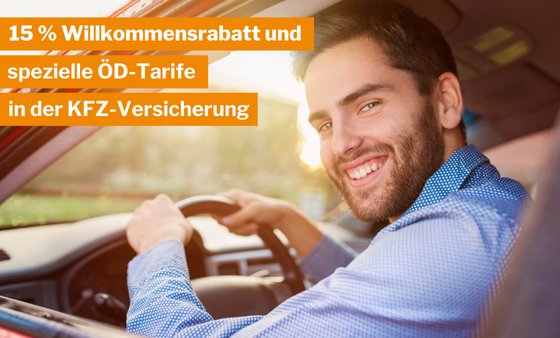 ein junger Mann im blauen Hemd lächelt zum Autofenster raus.