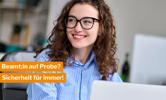 Beihilfekonforme Krankenversicherung der DBV Junge Beamtin mit blauer Bluse, lockigen Haaren und einer Brille lächelt
